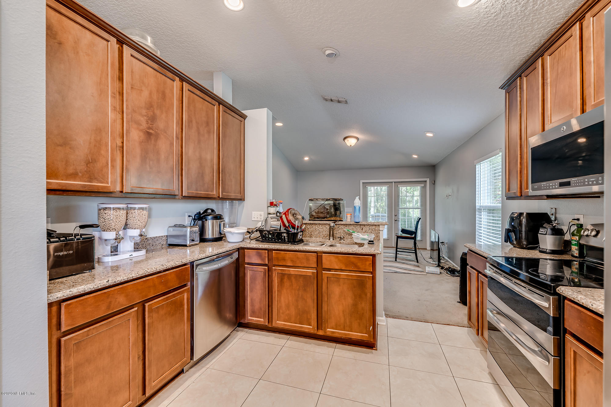a kitchen with stainless steel appliances granite countertop a sink counter space cabinets a stove and a refrigerator