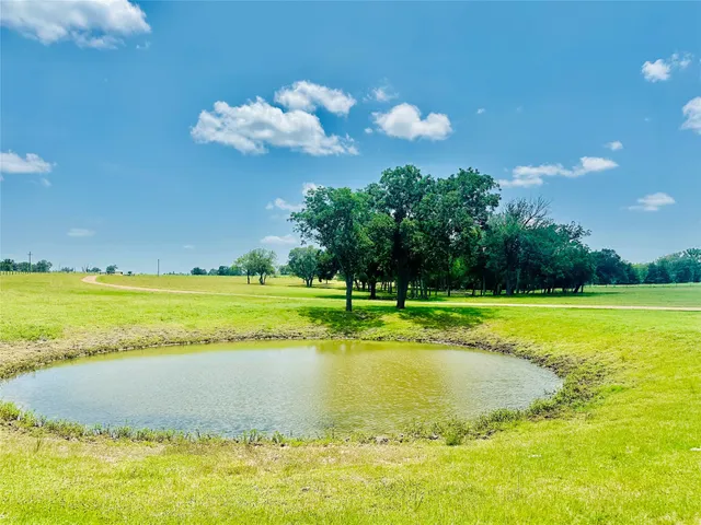 an aerial view of a house with a yard and lake view