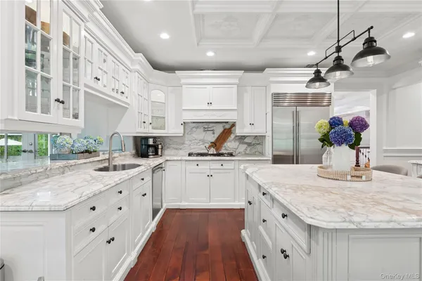 a kitchen with granite countertop a sink stainless steel appliances and white cabinets