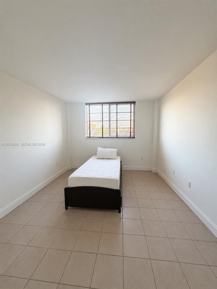 14170 Southwest 84th Street, Unit 404F Miami, FL 33183 - Photo 6 of 18 a spacious bedroom with a bed and window