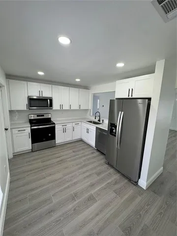 a kitchen with stainless steel appliances granite countertop a refrigerator and a stove top oven