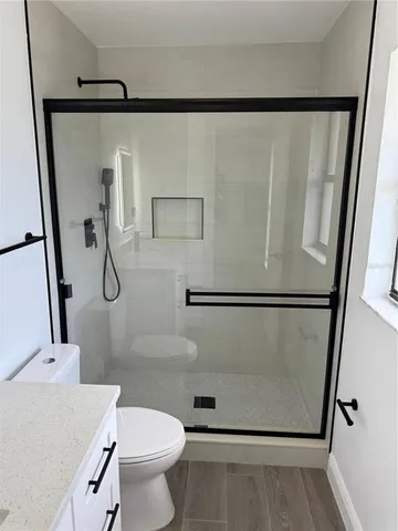a bathroom with a granite countertop shower and a sink