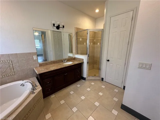 a spacious bathroom with a tub sink and mirror
