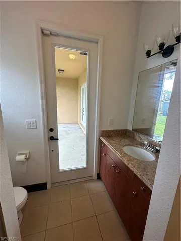 a bathroom with a granite countertop sink a toilet and mirror