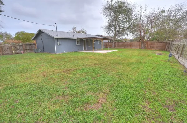 a front view of house with yard and trees in the background