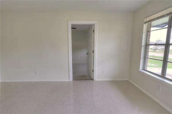an empty room with windows and closet