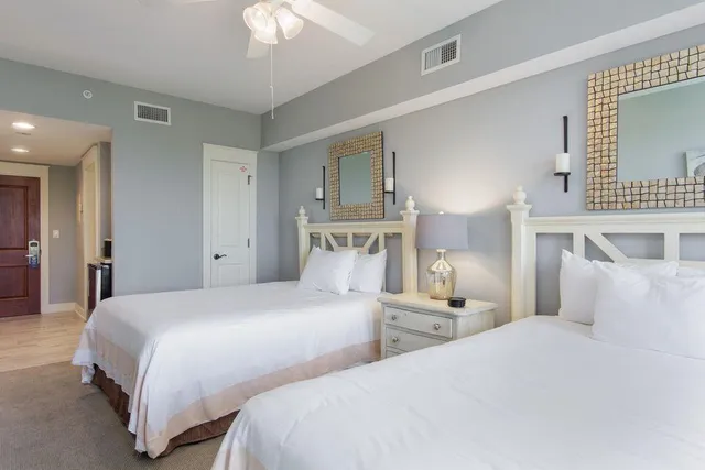 a bedroom with two beds and a chandelier