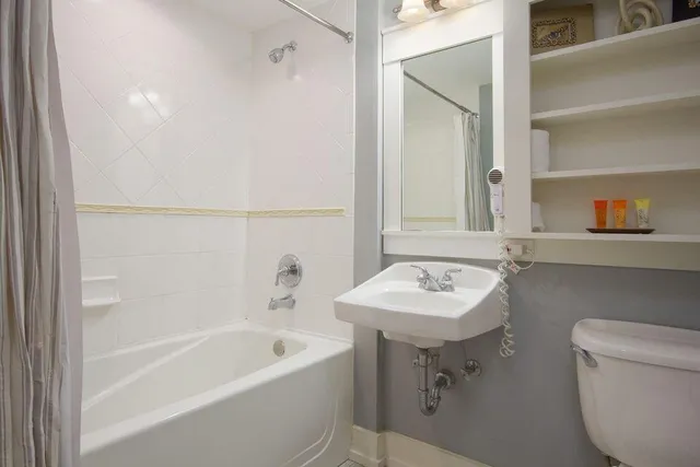 a bathroom with a sink mirror toilet and bathtub