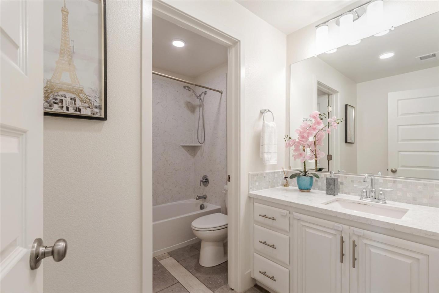 1653 Centre Pointe Drive Milpitas, CA 95035 - Photo 23 of 40 a bathroom with a granite countertop sink toilet a large mirror a shower and a mirror