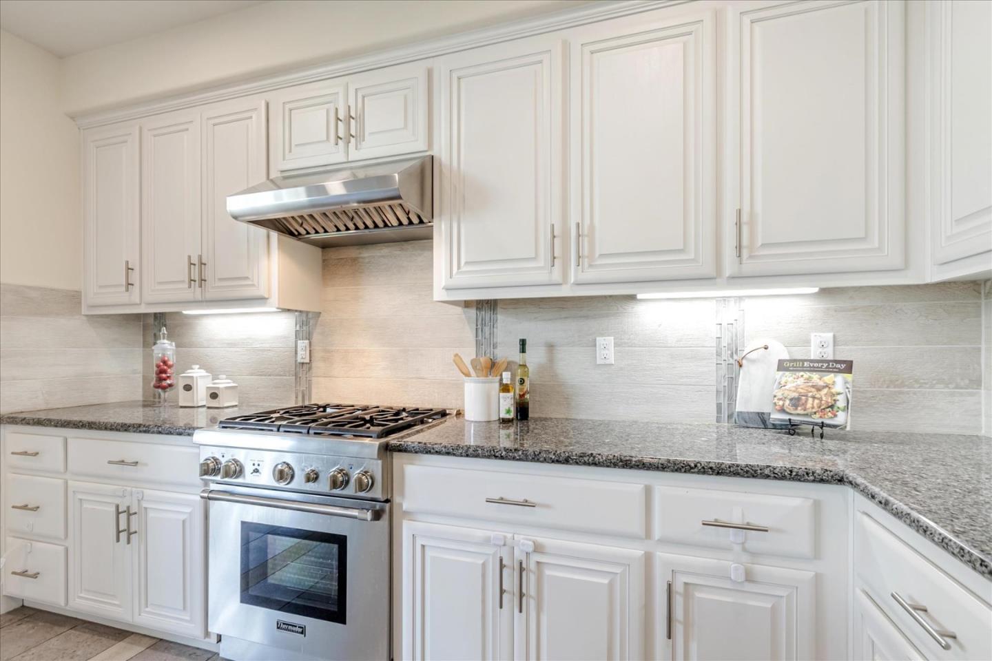 1653 Centre Pointe Drive Milpitas, CA 95035 - Photo 9 of 40 a kitchen with granite countertop white cabinets and white appliances