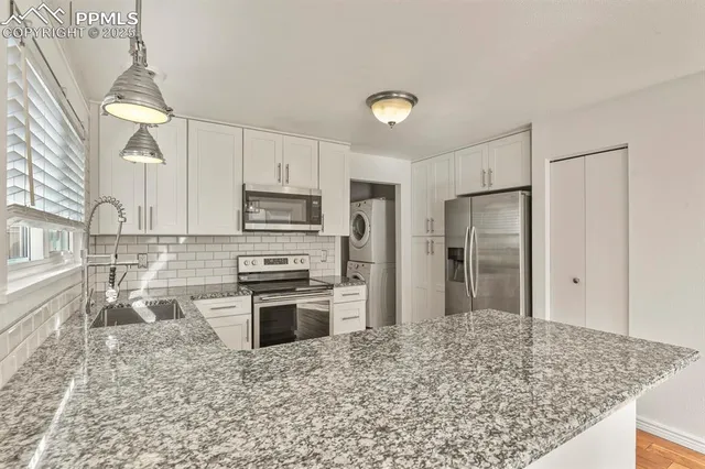 a kitchen with stainless steel appliances granite countertop a refrigerator sink and stove