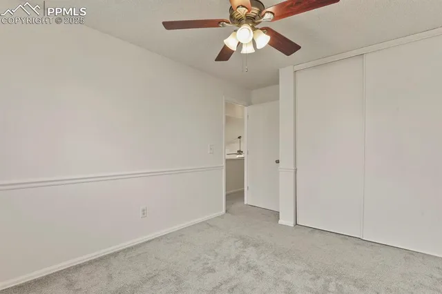 an empty room with chandelier fan