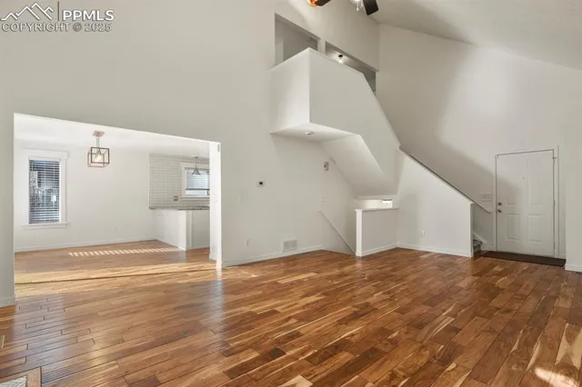a view of a big room with wooden floor and stairs