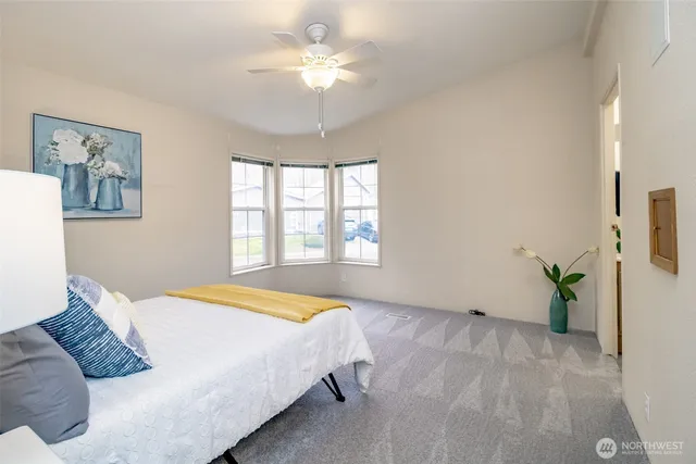 a bedroom with a bed chandelier and a window