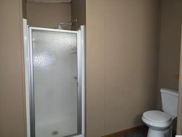 a bathroom with a granite countertop toilet and a sink