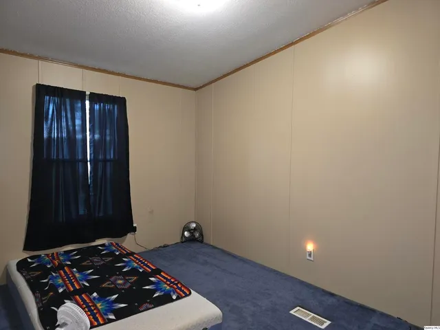 a room with a bed and a wooden floor