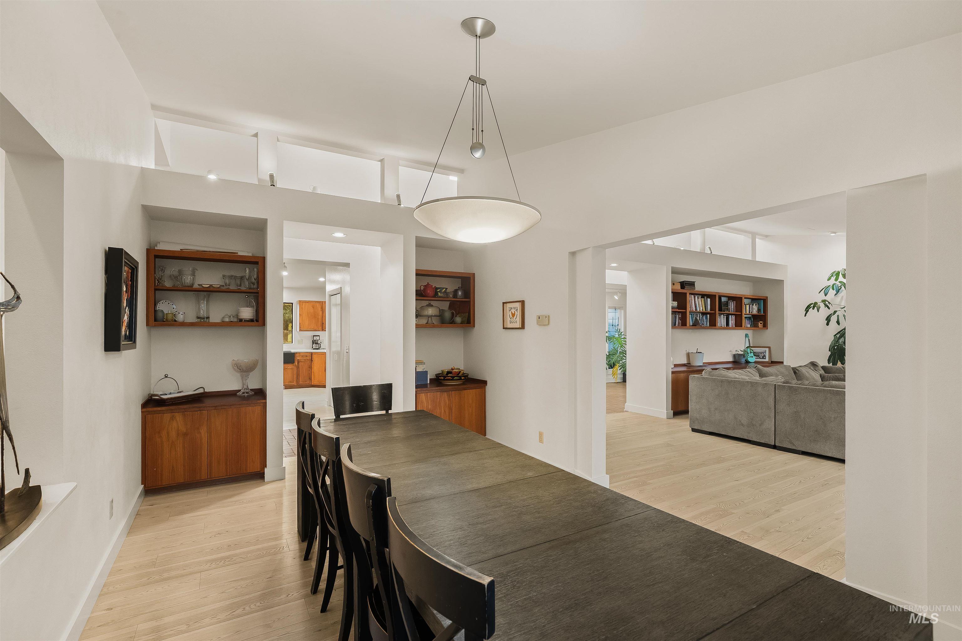2048 Arborcrest Road Moscow, ID 83843 - Photo 21 of 50 Dining area with light wood-finish flooring, built-in wooden cabinetry, and a contemporary pendant light fixture