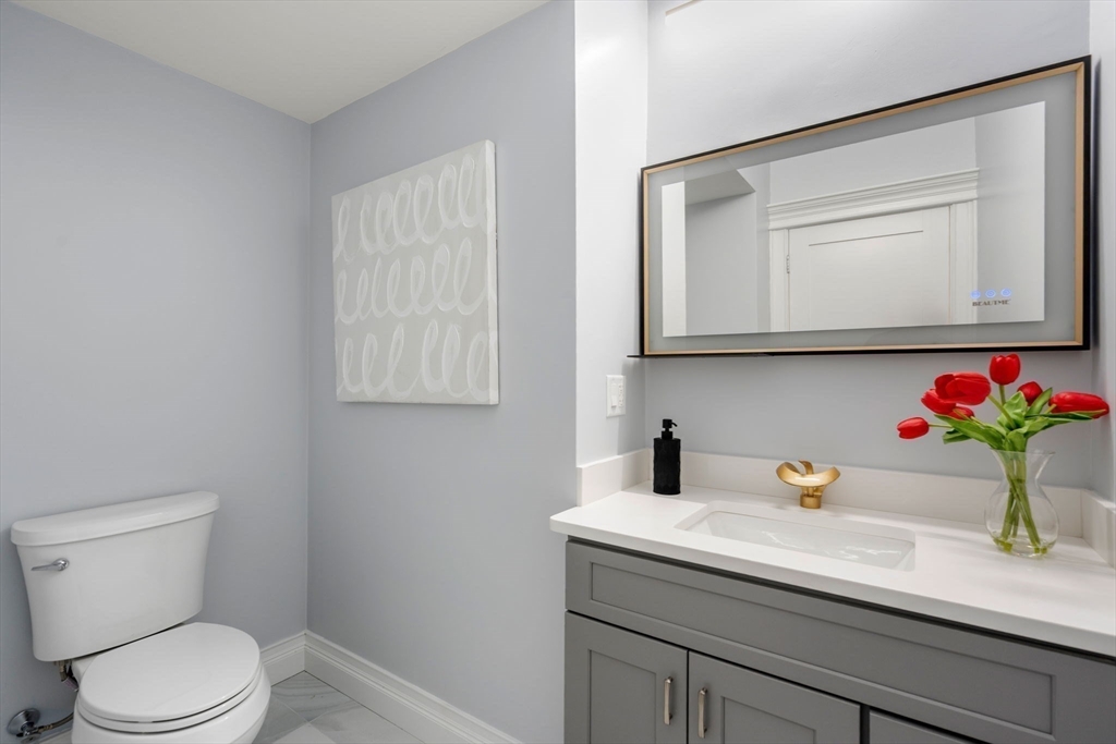 10 Hitching Post Lane Weston, MA 02493 - Photo 17 of 42 a bathroom with a toilet sink and mirror