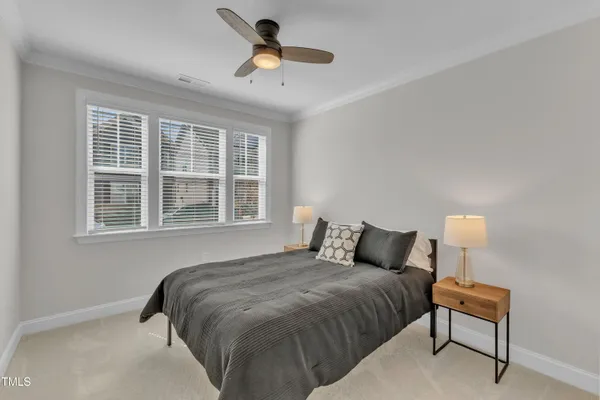 a bedroom with a bed and a lamp next to a window