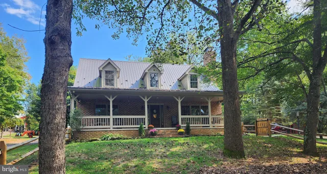 a view of a house with a yard and large tree