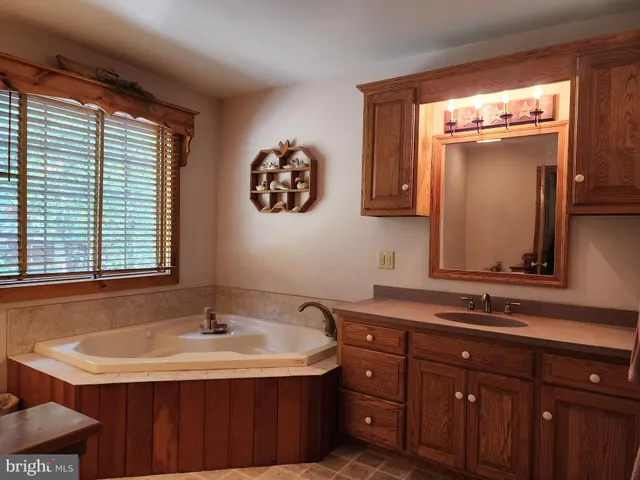 a bathroom with a double vanity sink toilet and a tub