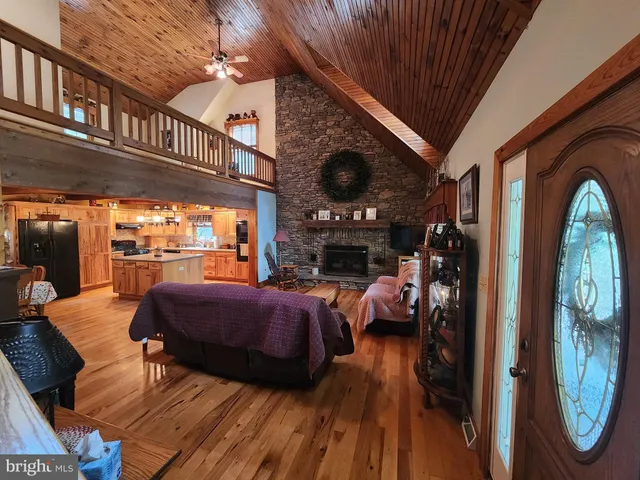 a kitchen with stainless steel appliances granite countertop a stove a refrigerator a sink a dining table and chairs with wooden floor