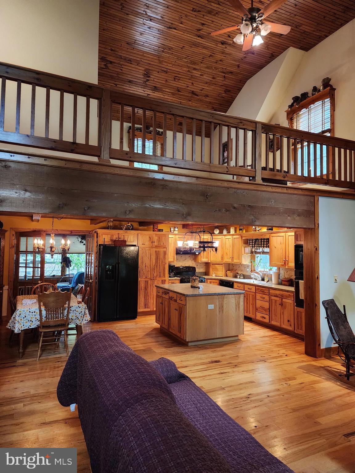 14847 White Oak Ridge Hancock, MD 21750 - Photo 7 of 101 a kitchen with stainless steel appliances granite countertop a stove a refrigerator a sink a dining table and chairs with wooden floor