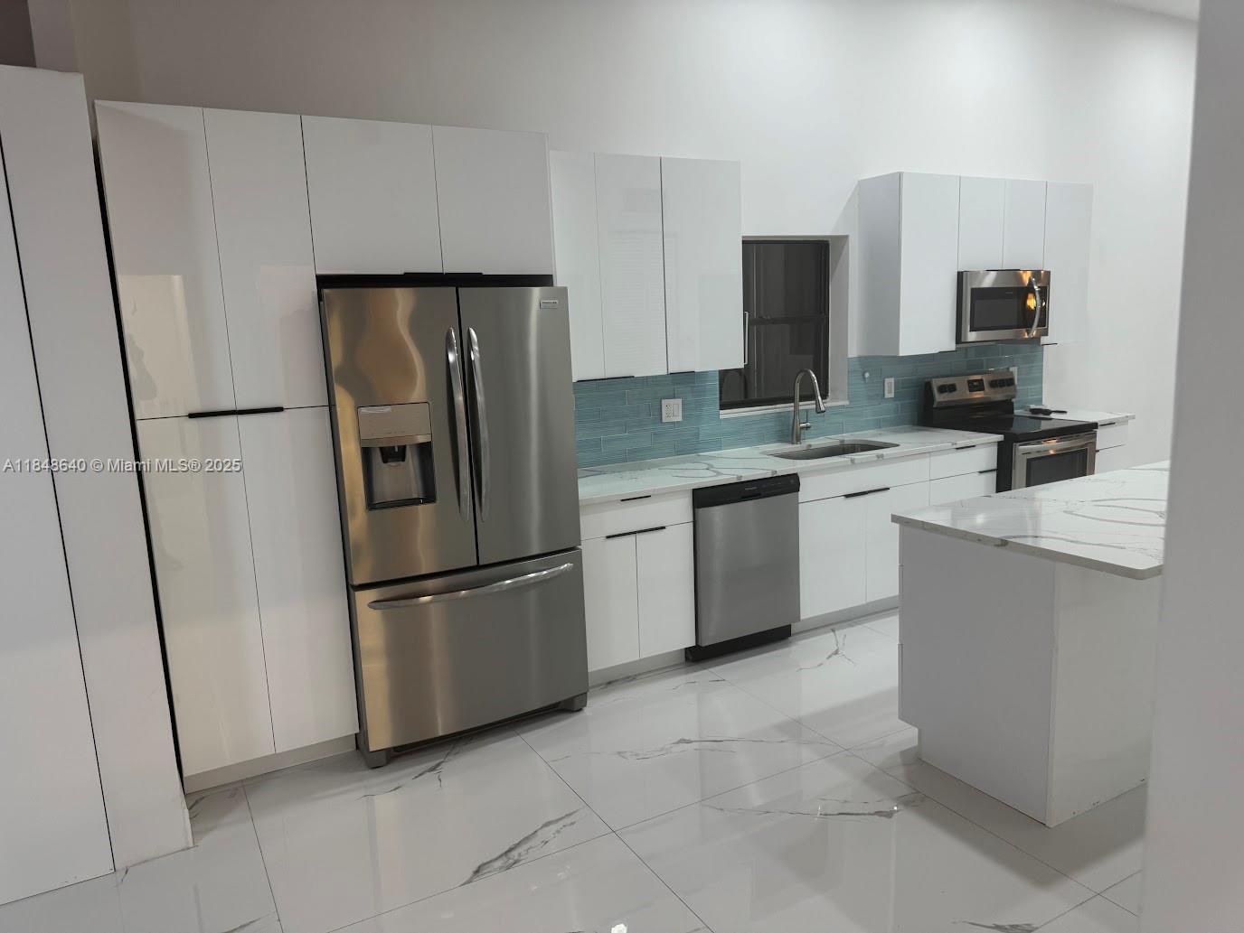 Three Islands Hallandale Beach, FL 33009 - Photo 5 of 10 a kitchen with stainless steel appliances a refrigerator sink and microwave