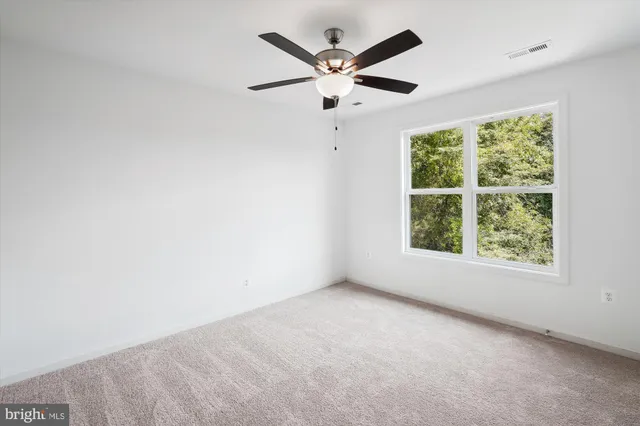 an empty room with chandelier fan