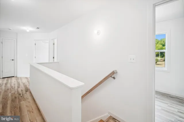 an empty room with chandelier fan and windows