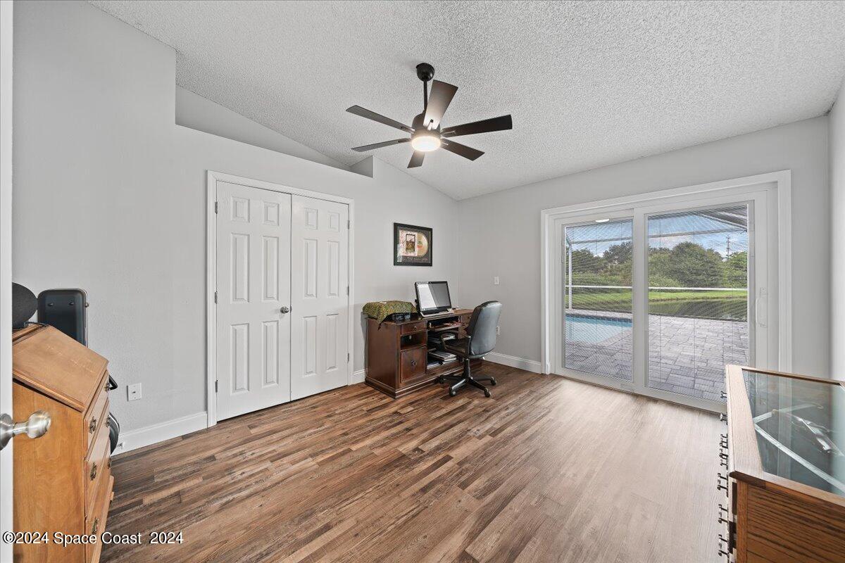 3905 Grand Meadows Boulevard Melbourne, FL 32934 - Photo 11 of 32 a work room with wooden floor and a ceiling fan