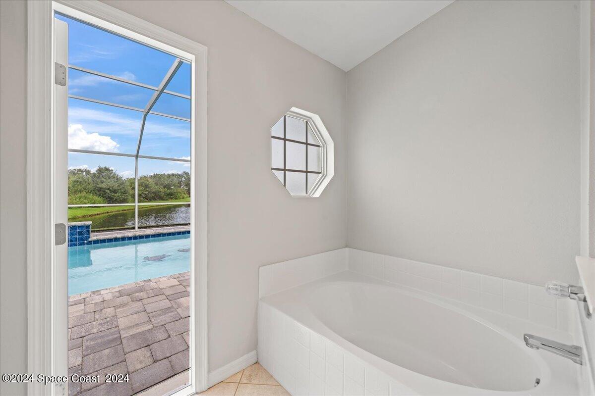 3905 Grand Meadows Boulevard Melbourne, FL 32934 - Photo 15 of 32 a bathroom with a tub a window and a shower