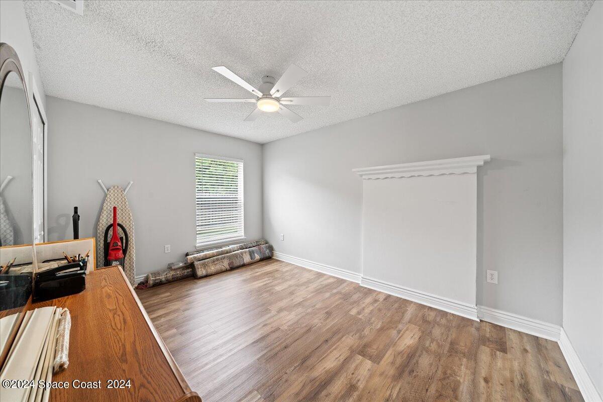 3905 Grand Meadows Boulevard Melbourne, FL 32934 - Photo 19 of 32 a view of a bedroom with wooden floor and a ceiling fan