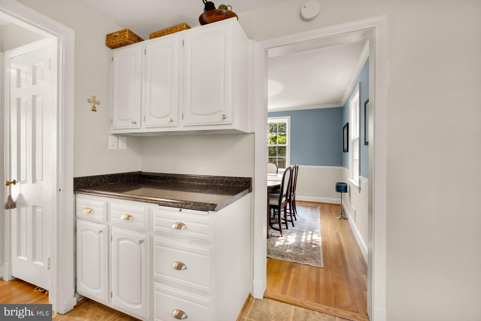 1802 August Drive Silver Spring, MD 20902 - Photo 8 of 26 a kitchen with a stove a refrigerator and white cabinets with wooden floor