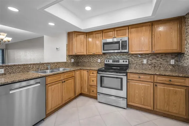 a kitchen with cabinets appliances a sink and a window