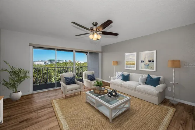 a living room with furniture a potted plant and a large window