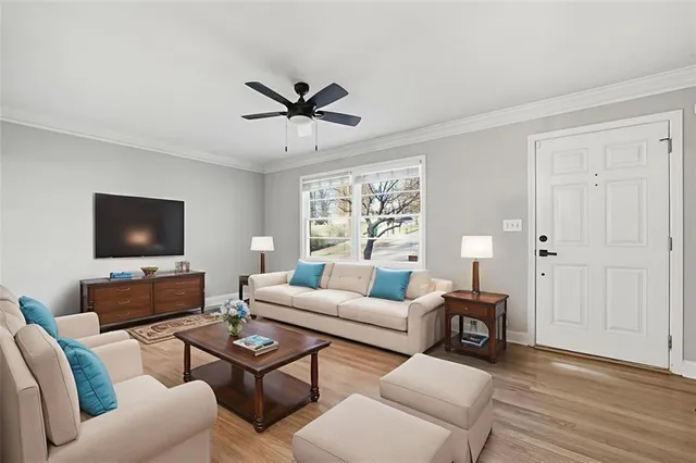 a living room with furniture a flat screen tv and a window