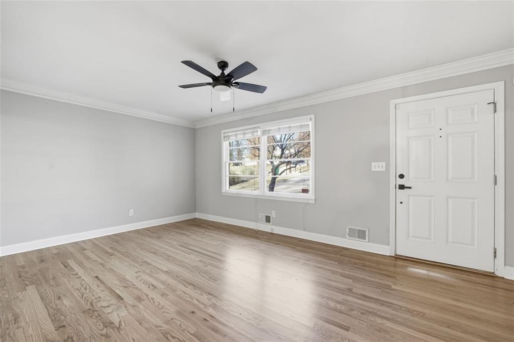 2002 Drew Valley Road Northeast Brookhaven, GA 30319 - Photo 5 of 51 an empty room with wooden floor fan and windows