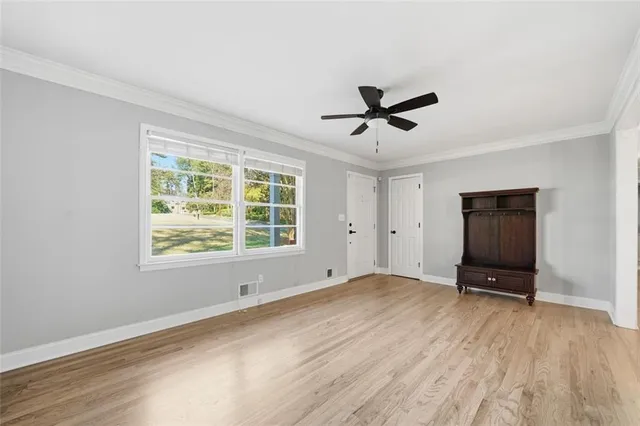 a view of an empty room with a window and a ceiling fan