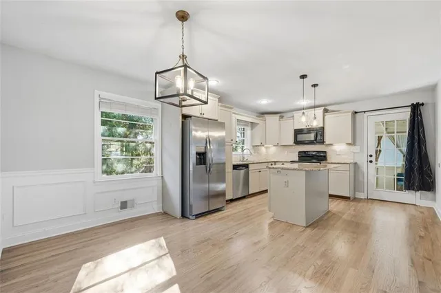 a kitchen with white cabinets and stainless steel appliances