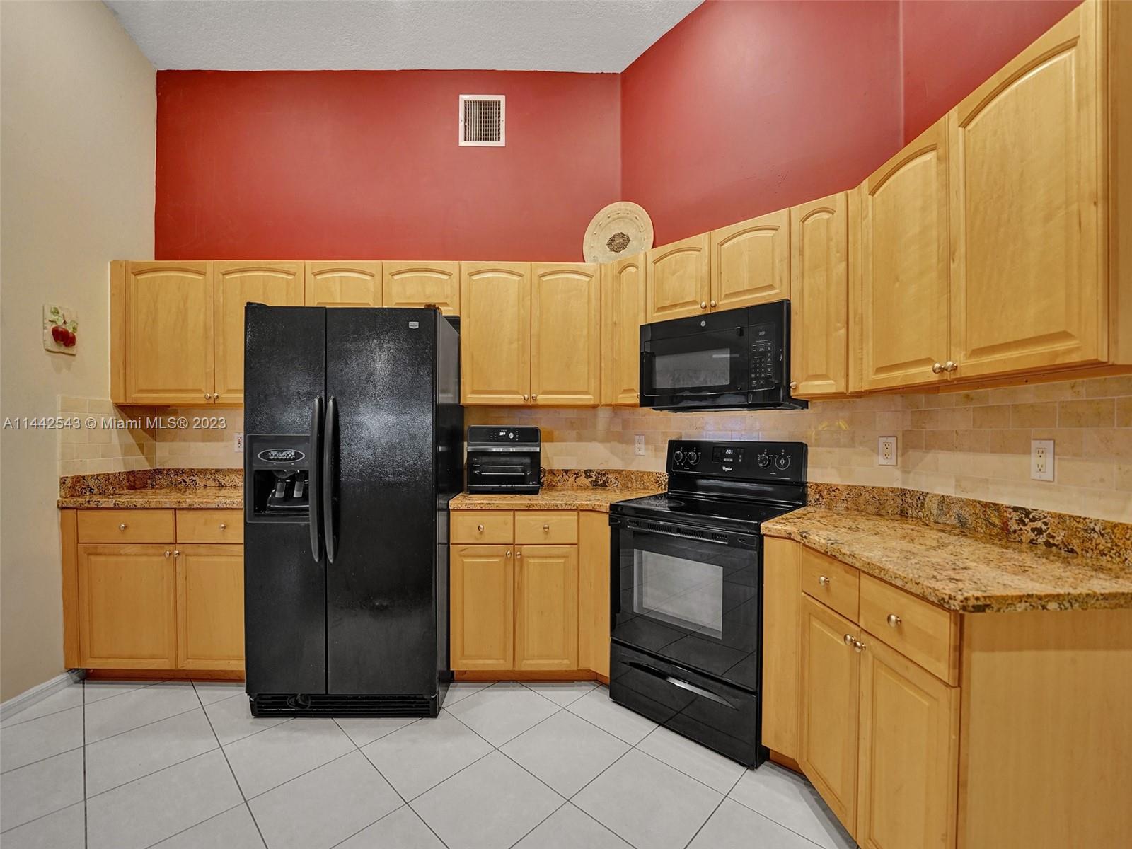 3273 Ridge Trace Davie, FL 33328 - Photo 24 of 74 a kitchen with stainless steel appliances granite countertop a refrigerator stove and microwave