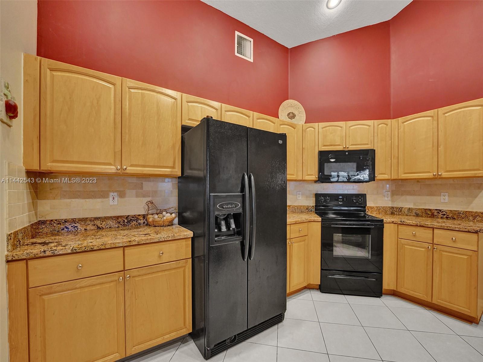 3273 Ridge Trace Davie, FL 33328 - Photo 25 of 74 a kitchen with stainless steel appliances granite countertop a refrigerator sink and stove