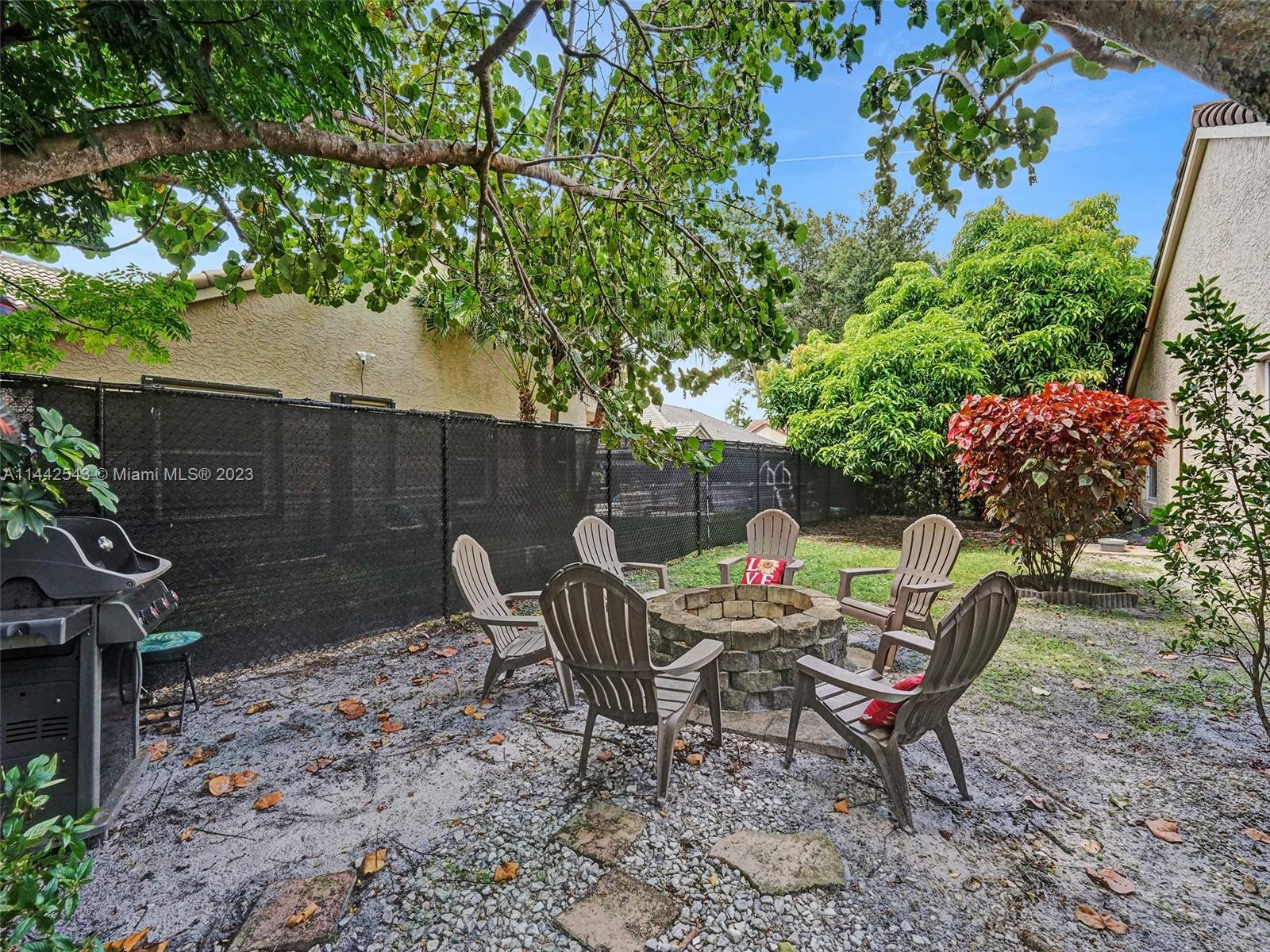 3273 Ridge Trace Davie, FL 33328 - Photo 68 of 74 a backyard of a house with table and chairs