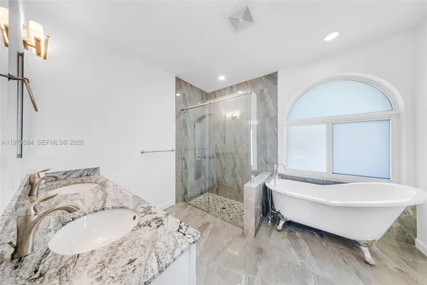 a bathroom with a tub sink and mirror