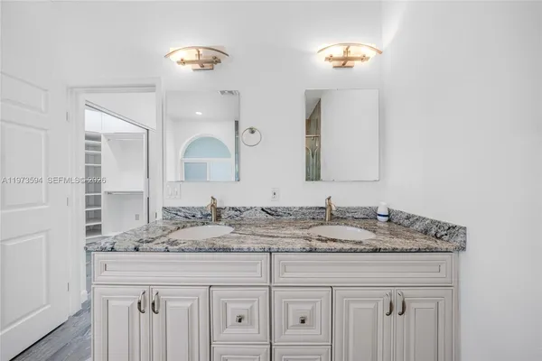 a bathroom with a double vanity sink and a mirror