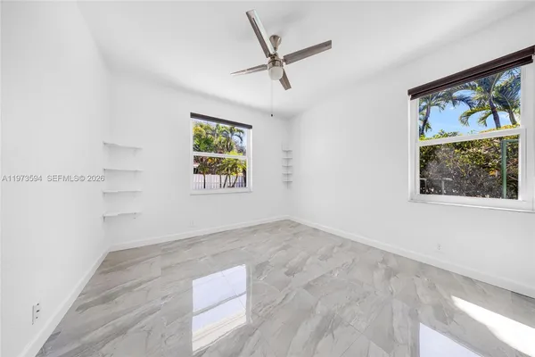 an empty room with a window and a ceiling fan