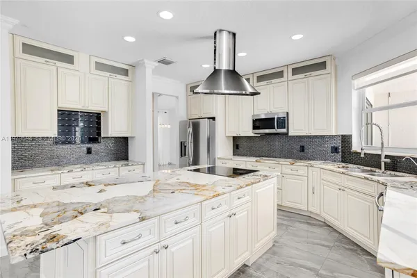 a kitchen with stainless steel appliances a sink stove oven and white cabinets