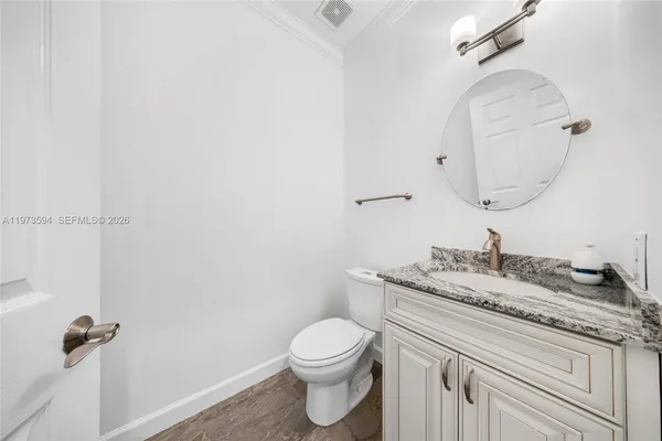a bathroom with a granite countertop sink a toilet and a mirror