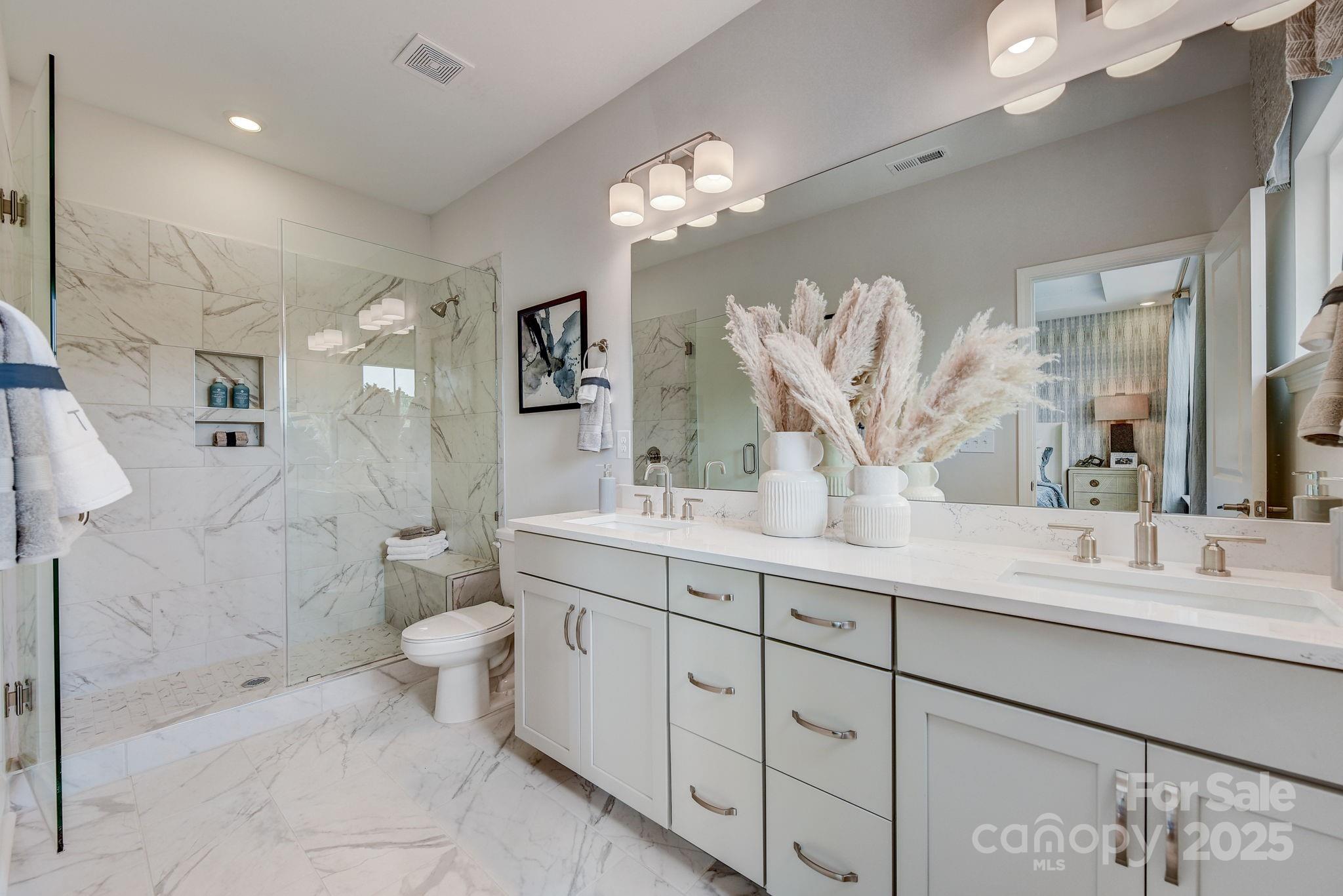 411 Jetton Street Davidson, NC 28036 - Photo 19 of 37 a spacious bathroom with a double vanity sink mirror and toilet