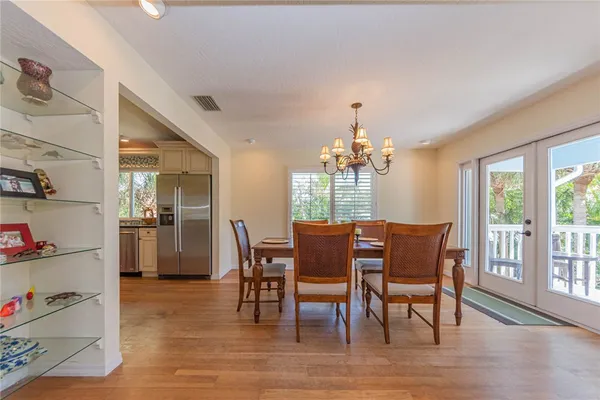 a dining room with furniture a chandelier and wooden floor